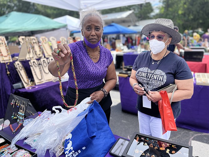 The Juneteenth Celebration featured 45 vendors. Artisan Catherine Queen-Newton of Treasures of the Queen shows a necklace to Jeanne Taylor of Burke. "I'm mesmerized by her work and wondrous artistry," says Taylor.
