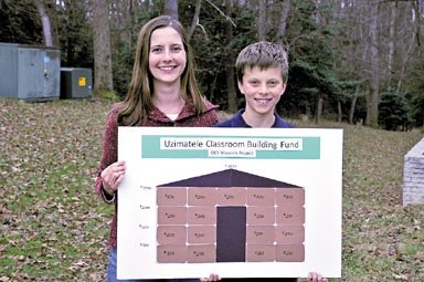 Laura Whittle and her son Sebastian Whittle, a 4th grader at Dominion Christian School, holding a poster indicating funds raised for the Uzimatele Educational Centre mission project in Nairobi. 