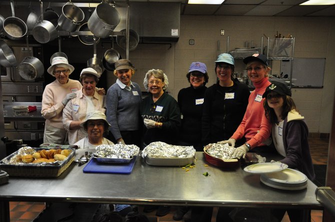 Volunteers from Thomas a Beckett Catholic Church prepare dinner at St. John Neumann Catholic Church for the homeless people staying the night as part of the FACETS Hypothermia Prevention Program. 