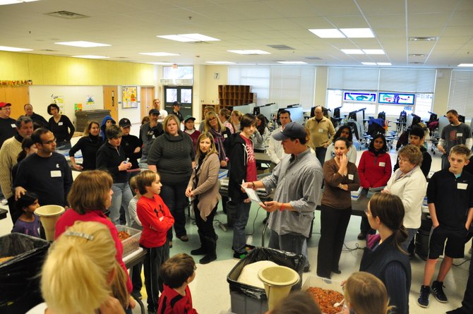 Dominic Alexander of Stop Hunger Now shows hundreds of volunteers how to package nonperishable meals to be send to starving people around the world at Colvin Run Elementary School Sunday, Jan. 22. The volunteers packaged more than 25,000 meals during the event. 