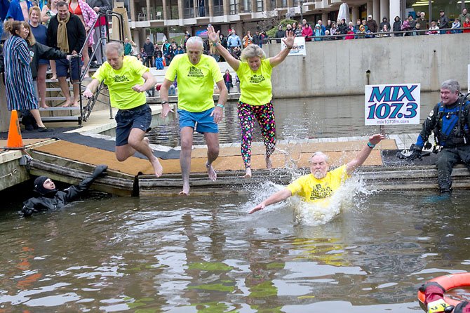 Team Reston Runners, organized by Karen Lovelace of Reston (second from right), with a collective age of 278 years, jumps into Lake Anne. Also jumping are Tim Cohn, Joe Fleig and Joe Stowers. 

