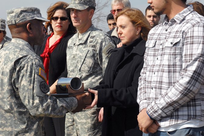 Command Sgt. Maj. Guitaud Leandre, 13th ESC, hands Cindy Hildner an artillery shell moments after it was fired from a cannon in her husband’s honor at Fort Hood Feb. 9. Brig. Gen. Terence J. Hildner, the 13th ESC commanding general died in Afghanistan Feb. 3 of apparent natural causes.

