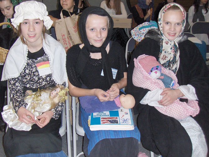 From left, three "immigrants" - Colleen Mulligan (Germany), Brennen McCarthy (Greece) and Emily Weidner (Ukraine) - with their "babies" and luggage. 