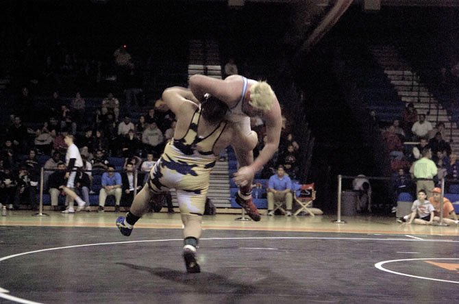 Robinson’s Jake Pinkston picks up Marshall’s Matt Crawford during the heavyweight final of the Northern Region wrestling championships on Feb. 11 at Hayfield Secondary School.