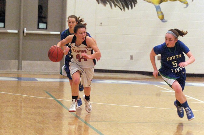 Megan LeDuc of Madison High races up the court with the ball as South Lakes’ Caitlin Jensen defends. LeDuc, a junior guard, was named to the All-Tournament Team following the Warhawks’ finals victory.