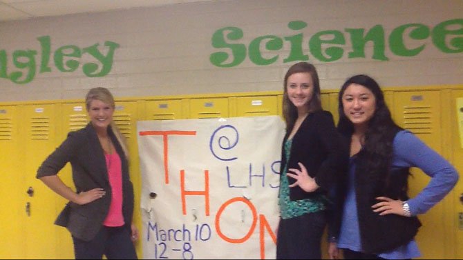 Langley leadership students Senior Holly Dodd, Lucy Gunter and Junior Charlee Vasiliadis in front of a poster advertising "Thon," a dance-a-thon to benefit veterans.