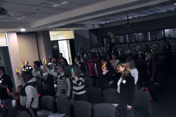 Participants in this year’s Relay for Life in Herndon hold up glow sticks to remember those they have lost to cancer at the event’s kickoff Wednesday, Feb. 15 at the Herndon Police Station. 