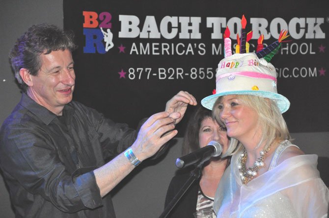 Pete DiCenso of the Dead Cat Bounce Band presents Julie Lansaw Warrin with a hat commemorating the McLean Project for the Arts 50th anniversary Friday, Feb. 24. DiCenso and his band performed the music for the evening. 