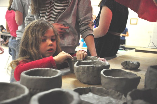 Mckenna Gurgo, 4, puts the finishing touches on her clay bowl at McLean High School Thursday, March 1. 