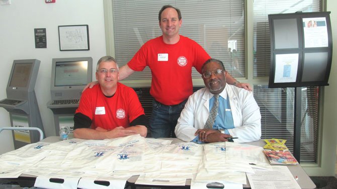 From left, Dr.Thomas Wilson, executive director of the Northern Virginia Dental Clinic in Falls Church; Dr. Peter Cocolis, chair of the 2012 Mission of Mercy Dental Fair, who has a dental practice in Springfield; and Dr. Howard Kelley of Vienna, chief dentist of NoVa’s Medical Education Campus, take time to greet patients and hand out literature on oral hygiene. All three were instrumental in organizing the two-day event. 