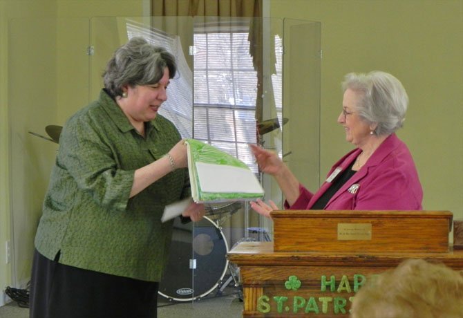 Phyllis Ainsworth (at right), Crafts Committee chairman of the Woman’s Club of McLean, presents a package of 57 pillowcases handmade by the group to Gina Cocomello.