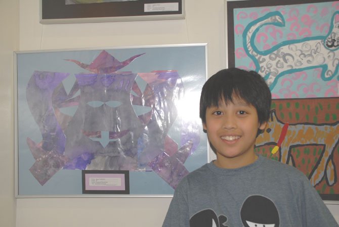 Justin Yudhistira, a fifth grader at Dogwood, with his art work featuring symmetrical design.