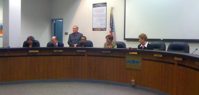 Alexandria Superintendent Morton Sherman, standing, waits for School Board members to call an executive session to consider the division's response to a scathing auditor's report.