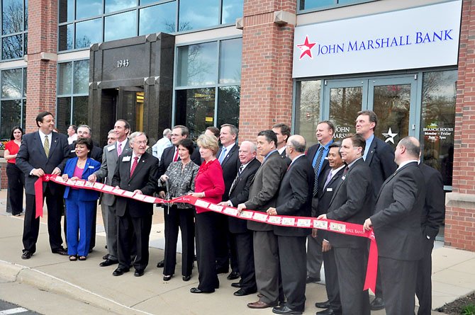 Local business leaders and elected officials prepare to cut the ribbon at the new John Marshall Bank branch and headquarters in Reston Thursday, March 15. 