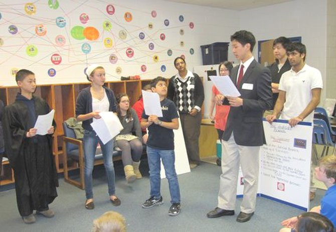 Pictured from left, re-enacting a case of a stolen iPod are Churchill Road 6th graders Chris Jiang (Judge), Valentina Deschler (Witness) and Darian Kaviani (Accused). From back left, Langley High School students Sarah Etherton, Stephanie Anderson (partially hidden), Nikita Thomas, Suzanne Kim, Jimmy Fang (Police Officer) and Nikhil Dua provide background information.