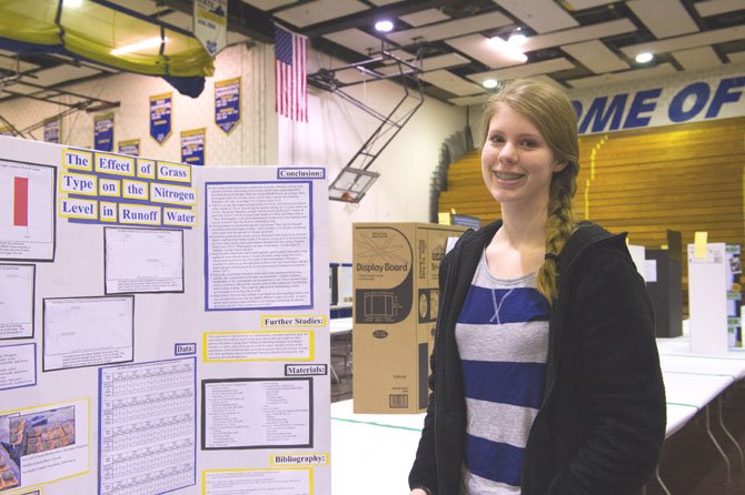 Megan McKinney, a junior at Mount Vernon High School stands next to her finished project board in the Robinson Secondary School field house just before the start of the 57th Fairfax County Regional Science and Engineering Fair on March 16. McKinney compared the rate at which different types of grass absorbed nitrogen. The goal would be to plant grasses that would reduce detrimental runoff into important watersheds.
   