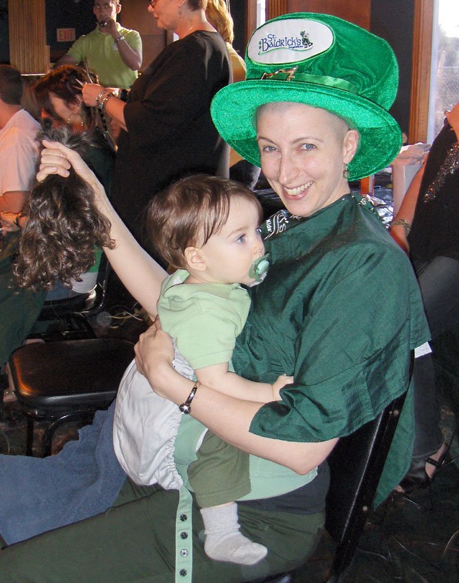 Samantha Lubkin holds her hair and her son Kai after being shaved at Centreville’s St. Baldrick’s day event Saturday at Fast Eddie’s.