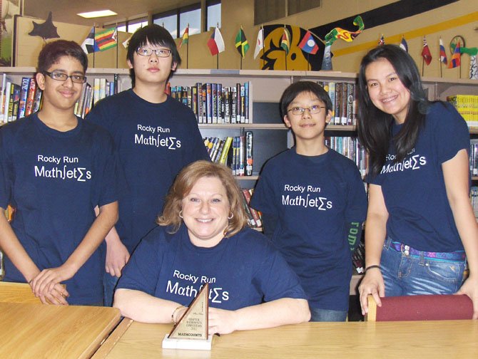 Wearing their “mathletes” T-shirts are Rocky Run’s MathCounts team members (from left): Rajat Khanna, team captain Robin Park, Alec Zhang and Joie Wang with coach Melanie Roller (seated) and their Chapter trophy.