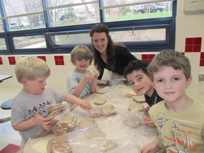 Churchill Road students begin service learning early.  Kindergartners Collin Walter, Luke Iverson, Jacob Sedaca and Jack Donohue, make sandwiches with the guidance of Jack's mom, Hannah Donahue.