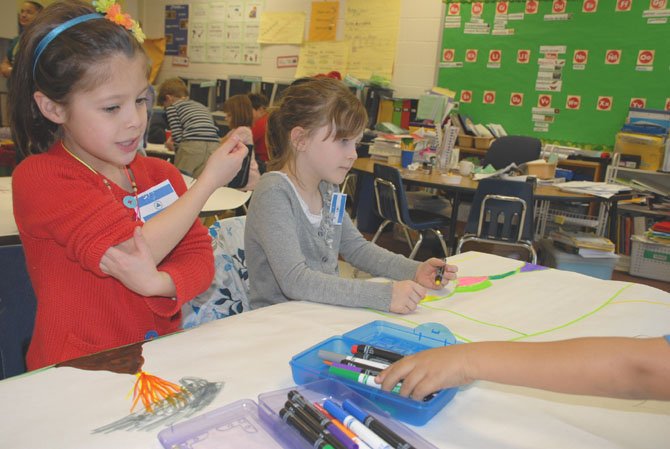 During a class party to celebrate Bachelet’s return from Nicaragua, Raquel Davis (left) drew a picture of a volcano like the twin volcanoes on Ometepe Island in Nicaragua where Bachelet traveled to in February. Grace Morgan, seated next to Davis, said that the bird she was assigned was the northern parula warbler. 

