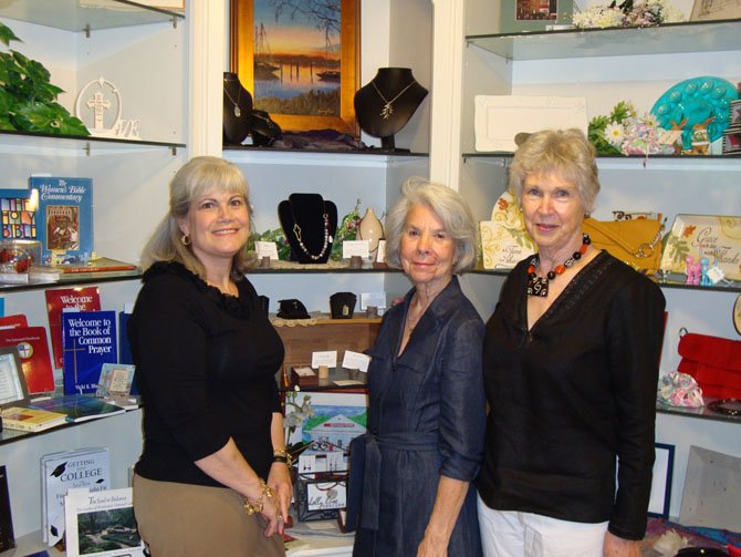 Historic Christ Church Gift Shop volunteers Holly Wright, Anna Willis and Kathy Moore (from left) present a display of jewelry by Tiffany Scott and oil paintings and reproductions by Nancy Ziegler that will be featured at an April 19 Meet the Artist exhibit at the Gift Shop.
