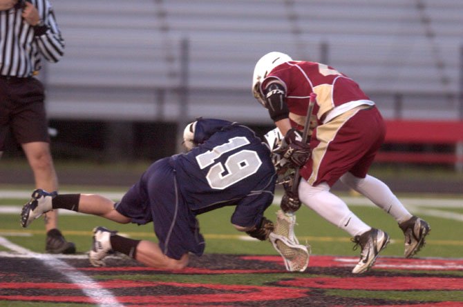Washington-Lee junior Dylan Leger, left, fights for draw control against Oakton on March 30.