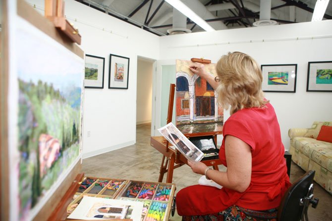 Carol Iglesias working on artwork at the Workhouse Arts Center. 

