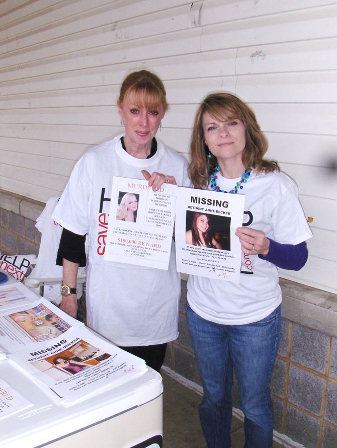 Gil Harrington (left) and Kim Nelson hold posters with their daughters’ photos and pass out information to local residents.
