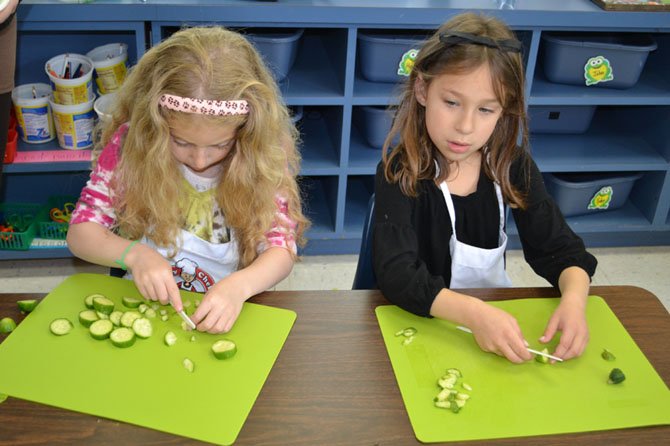 Kindergarten students at Norwood School in Bethesda/Potomac cut produce to make a vegetable pizza. Experts say cooking classes can boost self-confidence and enhance social skills.