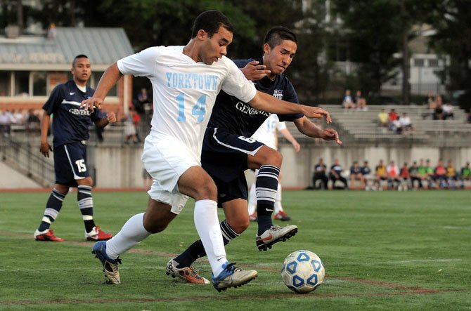 Yorktown senior Owen Howe and Washington-Lee junior Brian Romero battle for the ball during an April 16 contest at Greenbrier Stadium.