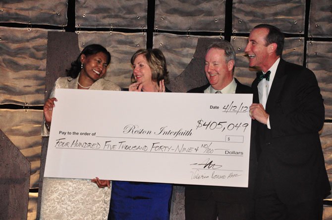 From left, Angela Harpalani, chair of Reston Interfaith and Kerrie Wilson, CEO of Reston Interfaith receive a check for $405,049 for Reston Interfaith from Tim Sargeant, chair of the Greater Reston Chamber of Commerce and Mark Ingrao, president and CEO of the Greater Reston Chamber of Commerce during the Best of Reston awards Thursday, April 12. 