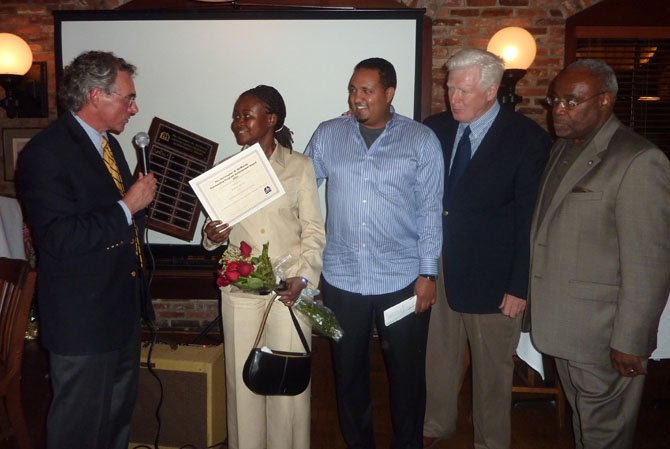 Community Lodgings board chairman Chris McMurray, left, presents Harriet Owusu with the Outstanding Achievement Award as her mentor, Besu Feleke of BB&T Bank, U.S. Rep. Jim Moran and Mayor Bill Euille look on.
