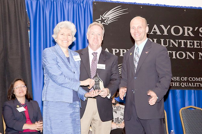 Tim Sargeant of Virginia Dominion Power accepts the Distinguished Corporate Service Award presented by Herndon Mayor, Steve J. DeBenedittis. Standing to his left: Peggy LeReche of Herndon-Reston FISH , while Council member, Grace Wolf (seated) looks on. 