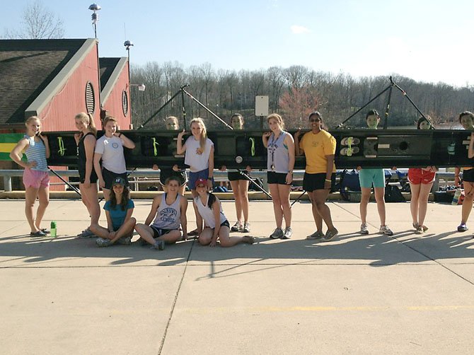 Some of the Langley women crew members displaying one of the boats that was re-laced in a show of support for Coach Hess.