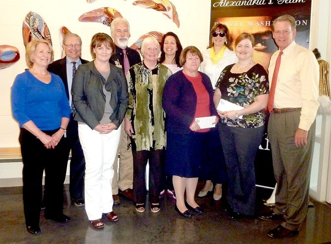 Executive Director Ann Dorman, left, joins First Night Alexandria board members April 19 in presenting checks to support local school music programs.