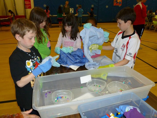 Pictured are second-graders trying to do everyday fine motor tasks.  The activity gave students a better understanding of autism.