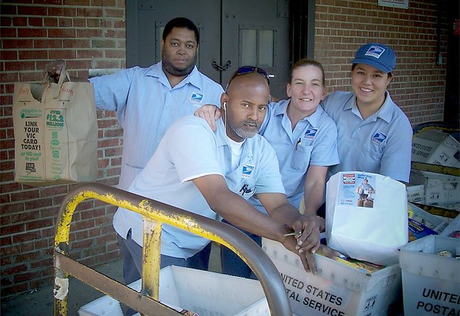 Otis Ginyard, Dwayne Chittum, Tracy Meyers, Nancy Nguyen help collect food for the upcoming Stamp Out Hunger Food Drive on May 12.