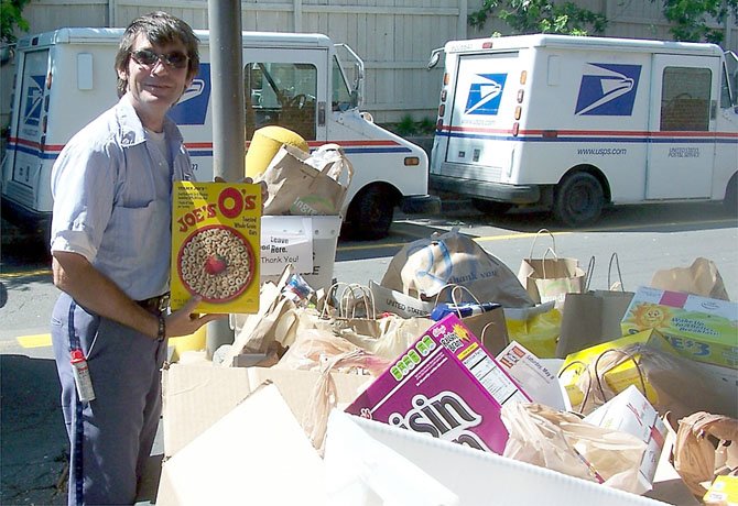 Kevin Martucci shows off the food collected for the upcoming Stamp Out Hunger Food Drive on May 12.