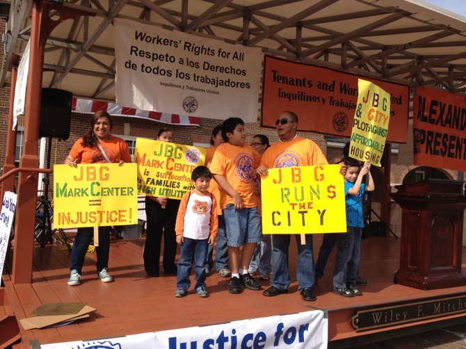 Hector Pineda, center right, holds a sign to protest a plan by developer JBG to demolish the building he lives in as part of a redevelopment plan that would more than double the allowable density.