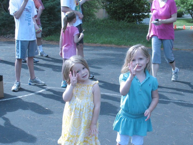 Two 3-year-olds, Emmy Brilliant and Grace Riihimaki. hold up four fingers when asked how many laps each of them did.

