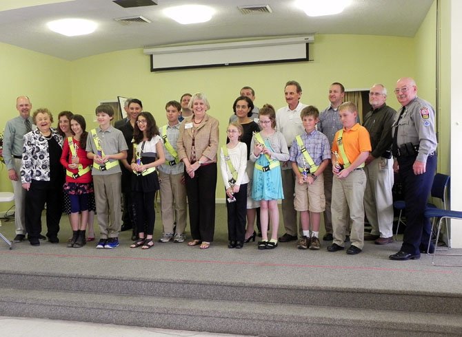 Safety patrol awardees (front row) with Woman’s Club education co-chair Catharine Stroemer (far left), county police school resource officer Tom Harrington (far right) and Woman’s Club president Ginny Sandahl (center); parents and supporters are behind. 