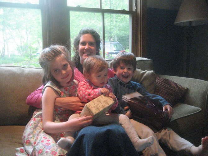 Elizabeth Rees with children Sophia (now 8), Dylan (now 5) and Maya (now 2). This picture was taken on Pentecost last year. I'm a priest, and this picture is taken after church. I was exhausted and relaxing on the couch, and all the kids came over to snuggle with me.
