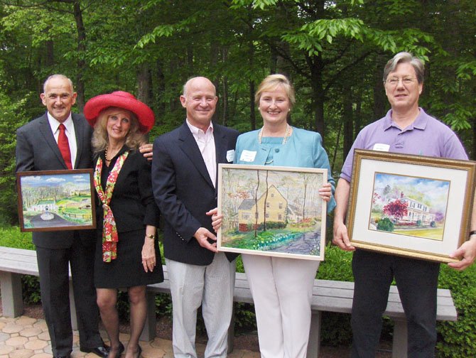 From left: Rob Airaghi, Lynne Garvey-Hodge, Joe and Vickie Luchini and Brant Baber hold the paintings of their homes done by artists Trudi Arnold and Peggy Cranston. They were honored Sunday at a homeowners’ reception at the Fairfax Station home of Sharon and Mark Gottlieb. (Not pictured are Kathy Kalinowski and Lisa and Paul Brockman).
