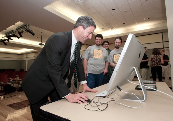 Virginia Attorney General Ken Cuccinelli plays a game created by George Mason Game Design students in Dewberry Hall at Fairfax Campus. The students created interactive and educational games aimed at teaching kids about the risks of joining gangs. 
 
