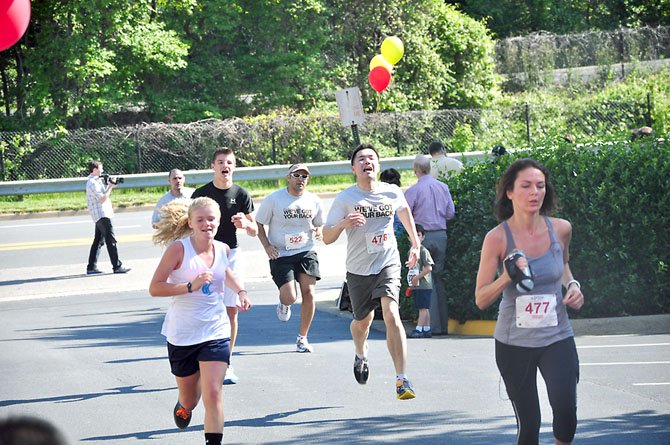 Runners cross the finish line during the fifth annual "We’ve Got Your Back" 5K in Reston Saturday, May 12, which raised more than $100,000 for the Spinal Research Foundation. 