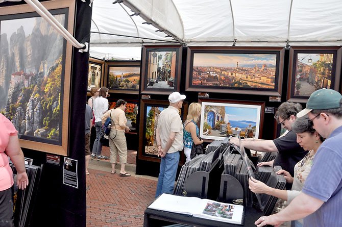 Visitors to the Northern Virginia Fine Arts Festival 2011 browse the work of John Scanlan, a photographer from Glenwood, Iowa.  

