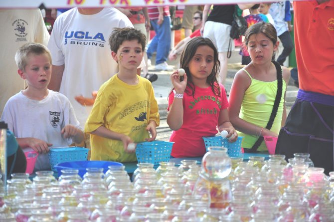 Children throw ping-pong balls for a chance to win goldfish at McLean Day, Saturday, May 19. 