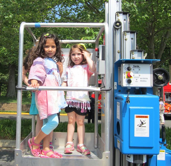 Zefora Rapapport and Leah Rosenstein, age 5, ride the cherry picker.