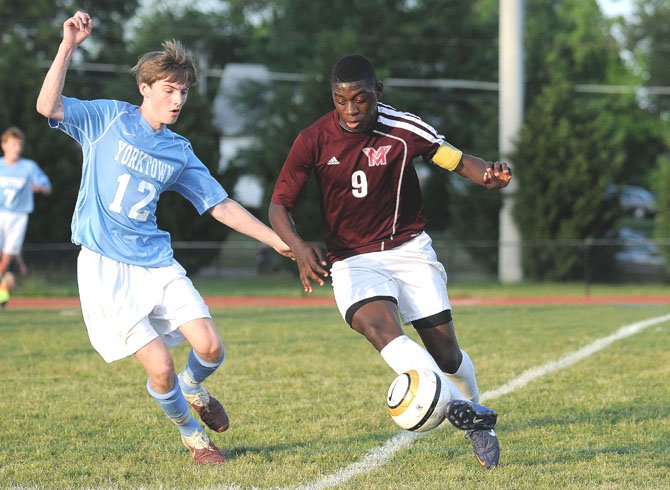Mount Vernon senior Amardo Oakley, right, dribbles against Yorktown’s Jack Walten during the National District tournament final on May 18.