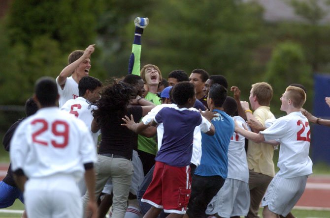 T.C. Williams goalkeeper Nick Braun raises his right arm in celebration after his two saves during a penalty-kick shootout helped the Titans beat Stuart in the opening round of the Northern Region tournament on May 22.